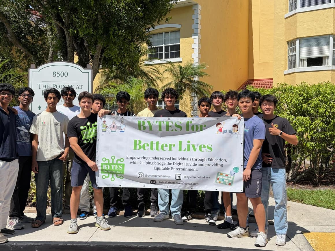Chapter members gathered behind a Bytes for Better Lives banner